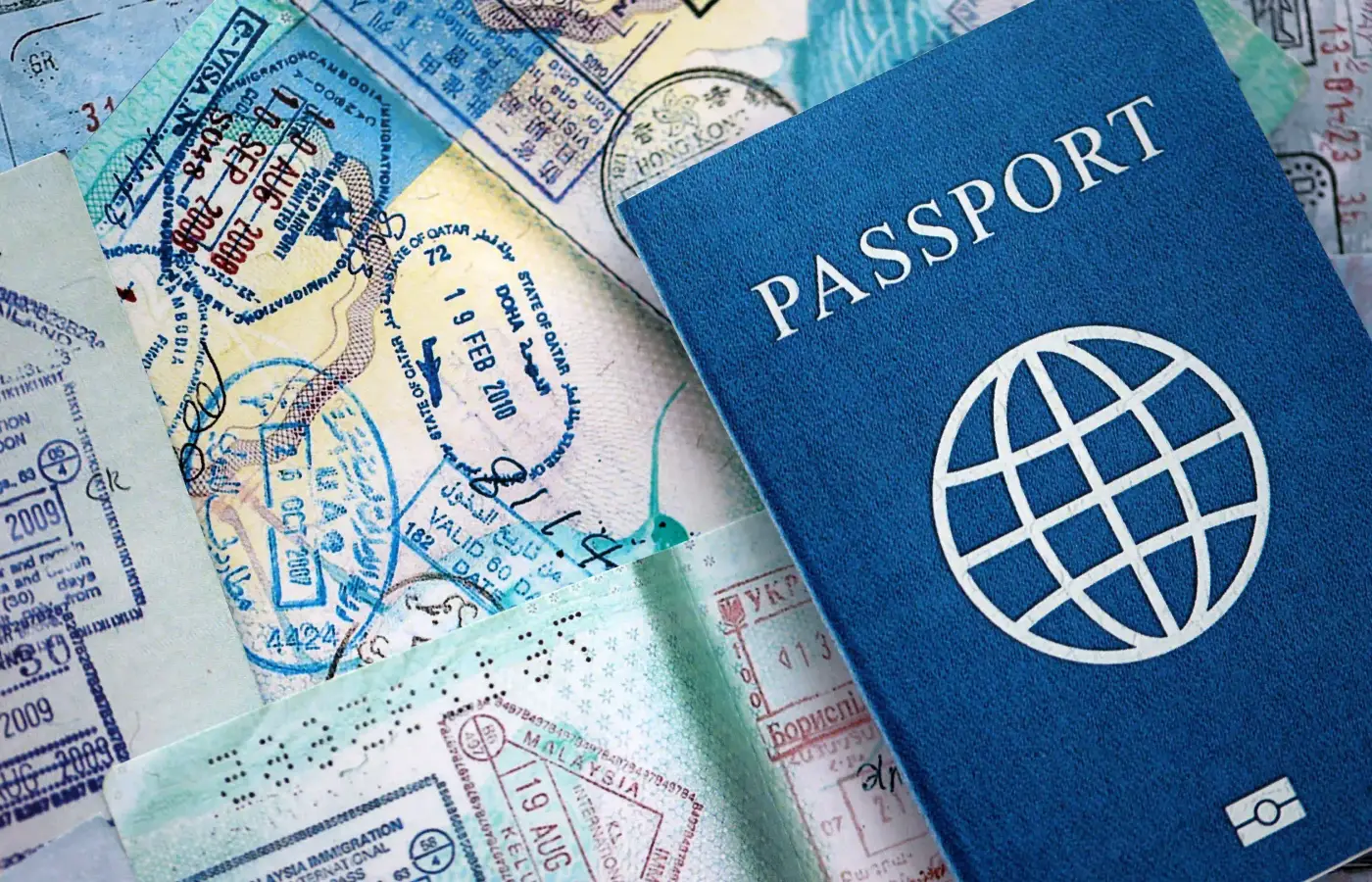 Ein Reisepass liegt auf Seiten voller Visumstempel