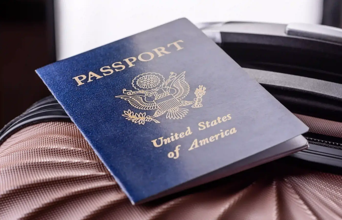 Un passaporto appoggiato su una valigia chiusa