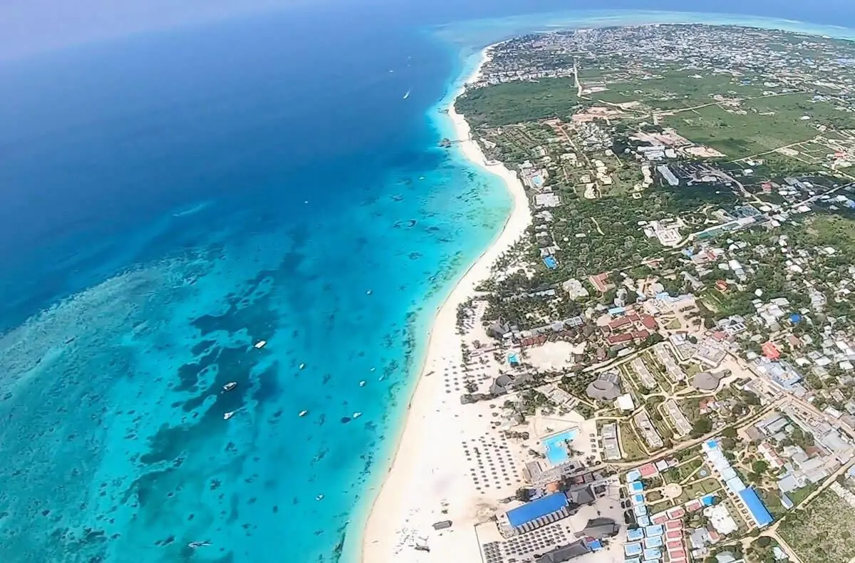 Aerial view of a Zanzibar beach town, white sand and reef water