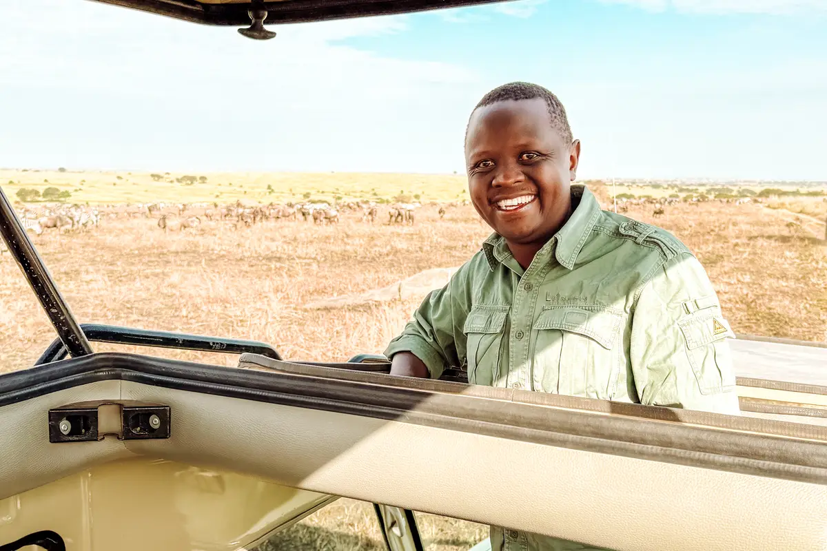 Ein Safari-Soles-Guide neben einem Safari-Land-Cruiser