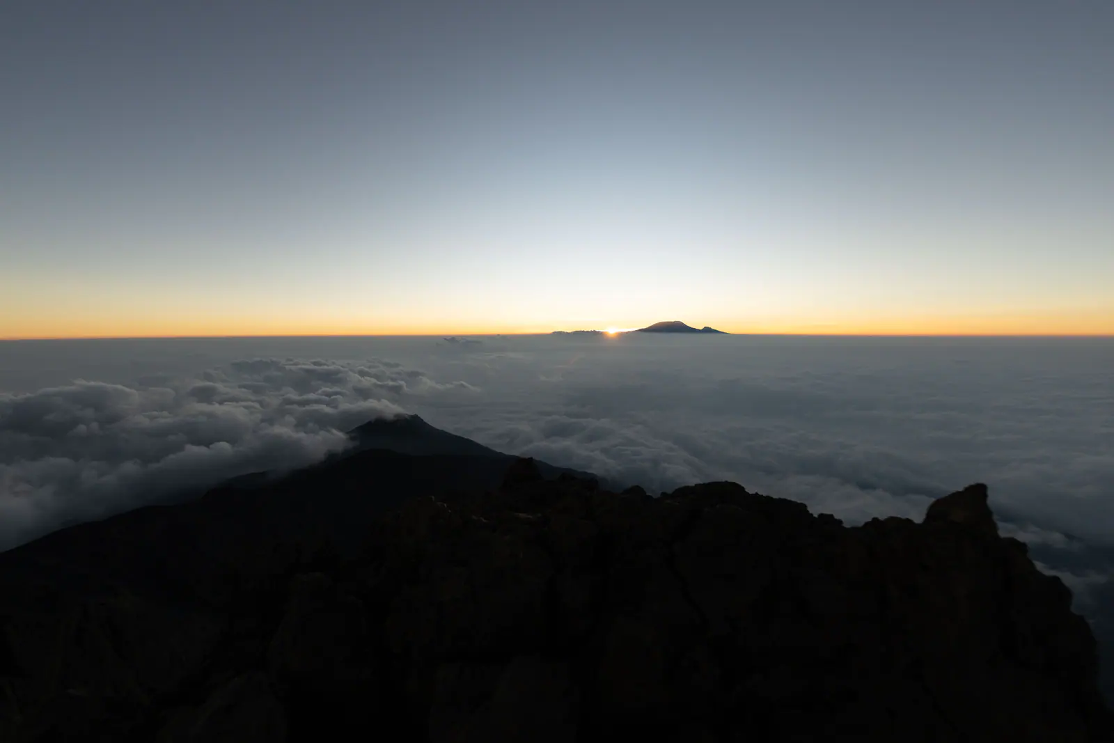 Mountain peaks rising through a cloud sea