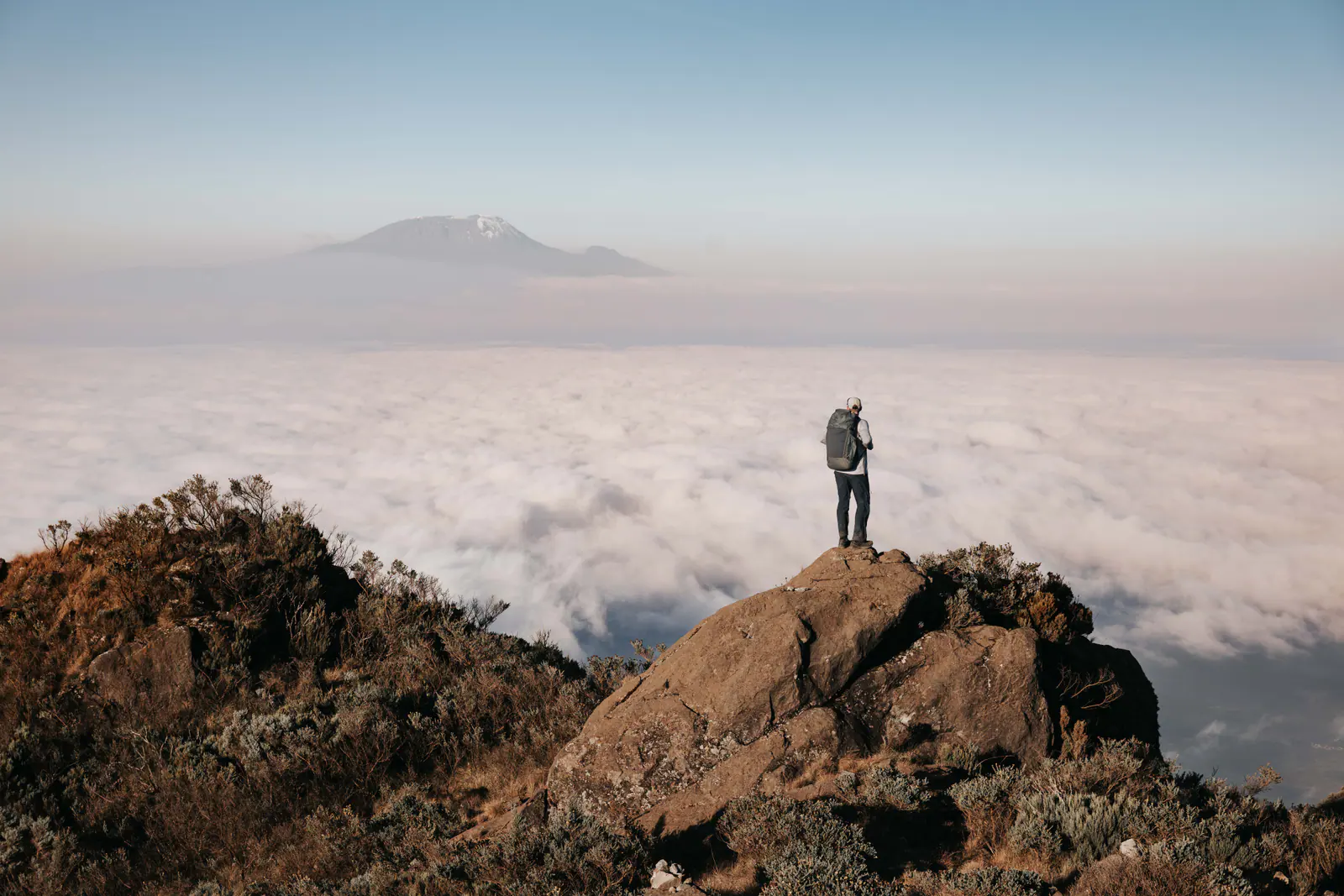 A trekker high on the mountain above a sea of clouds