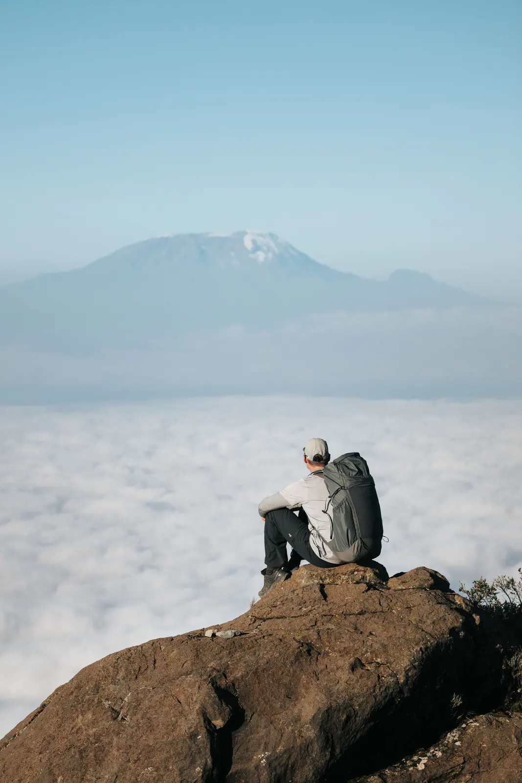 Un excursionista en lo alto de la montaña sobre un mar de nubes