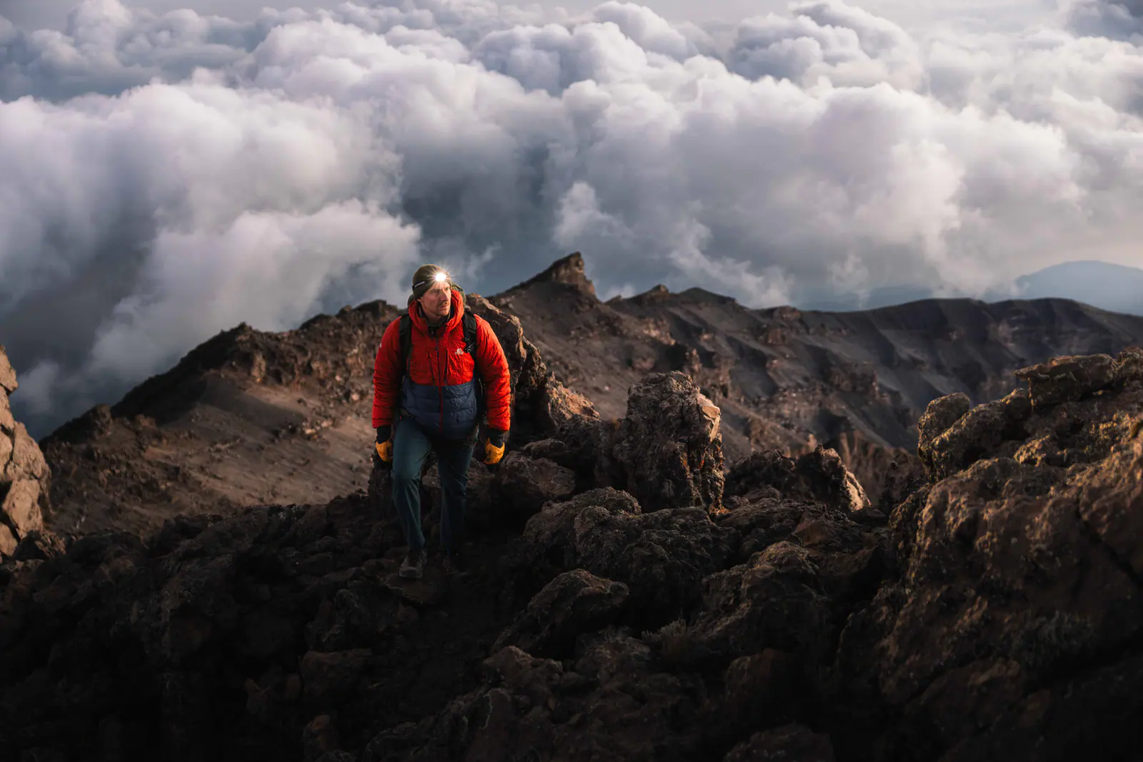A trekker high on the mountain above a sea of clouds