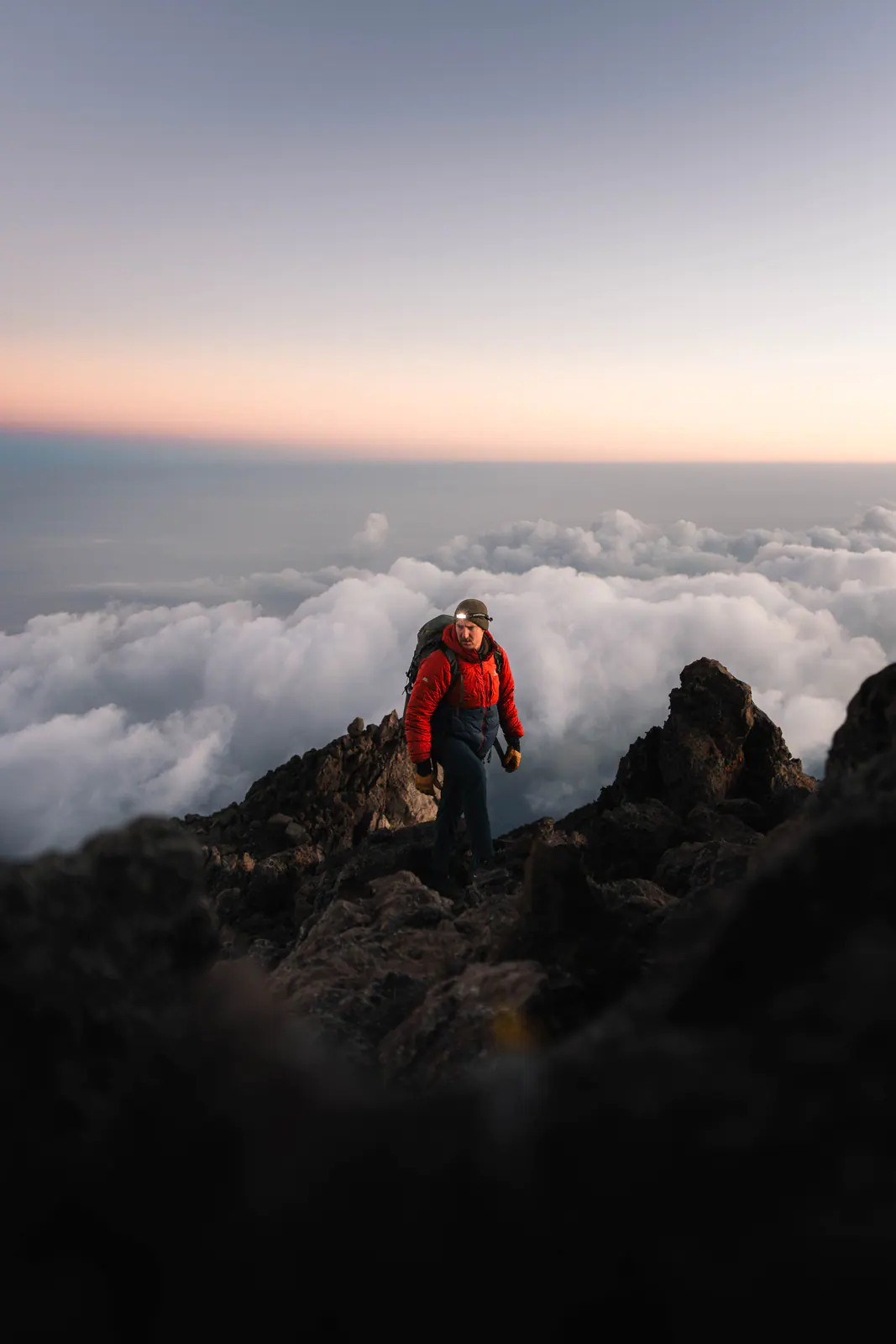 A trekker high on the mountain above a sea of clouds