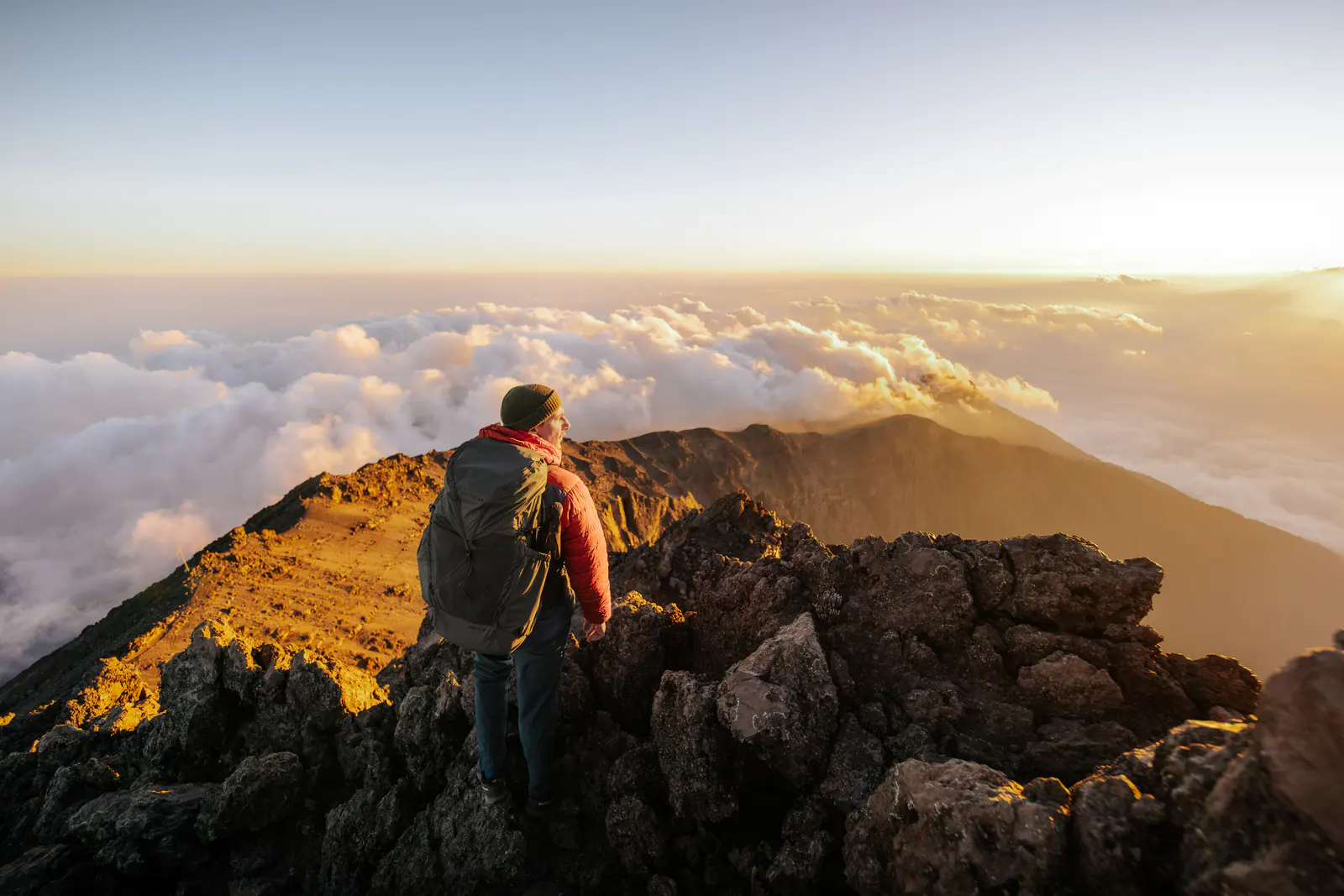 A trekker high on the mountain above a sea of clouds