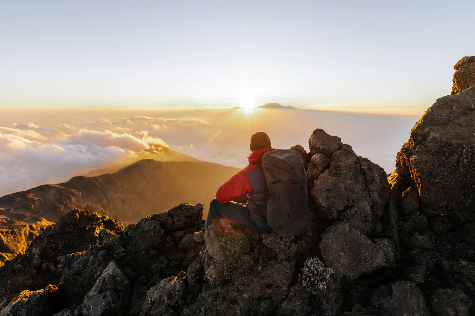 Ein Wanderer hoch am Berg über einem Wolkenmeer