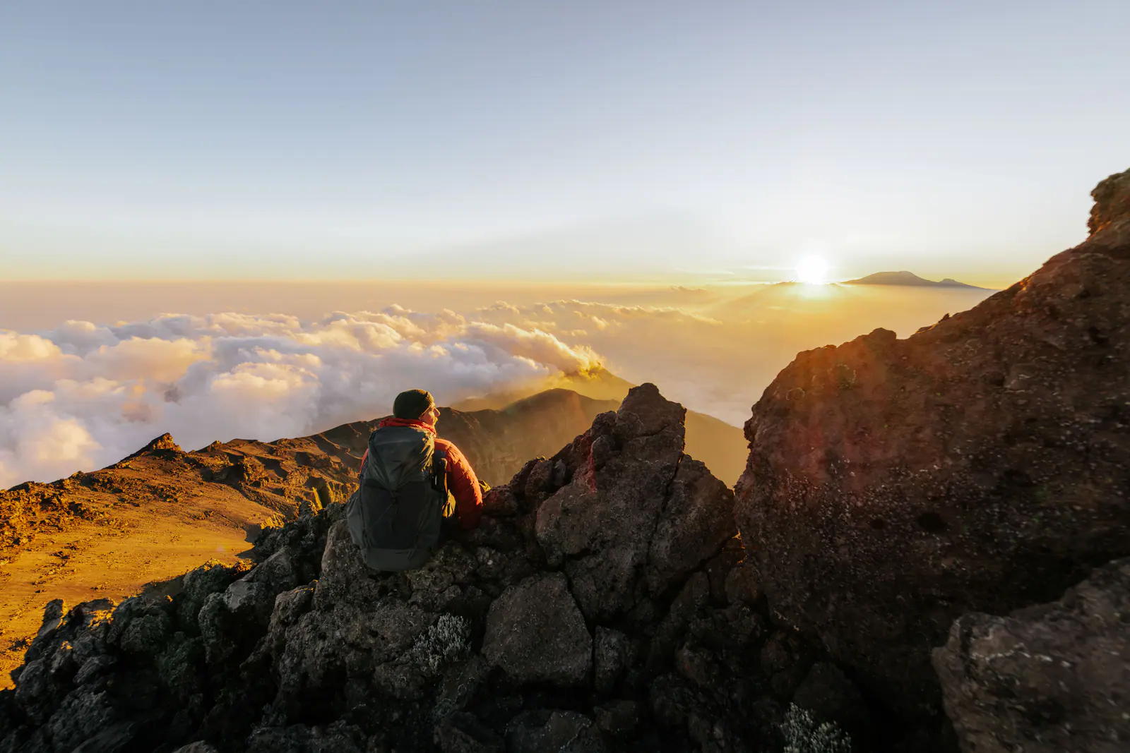 A trekker high on the mountain above a sea of clouds