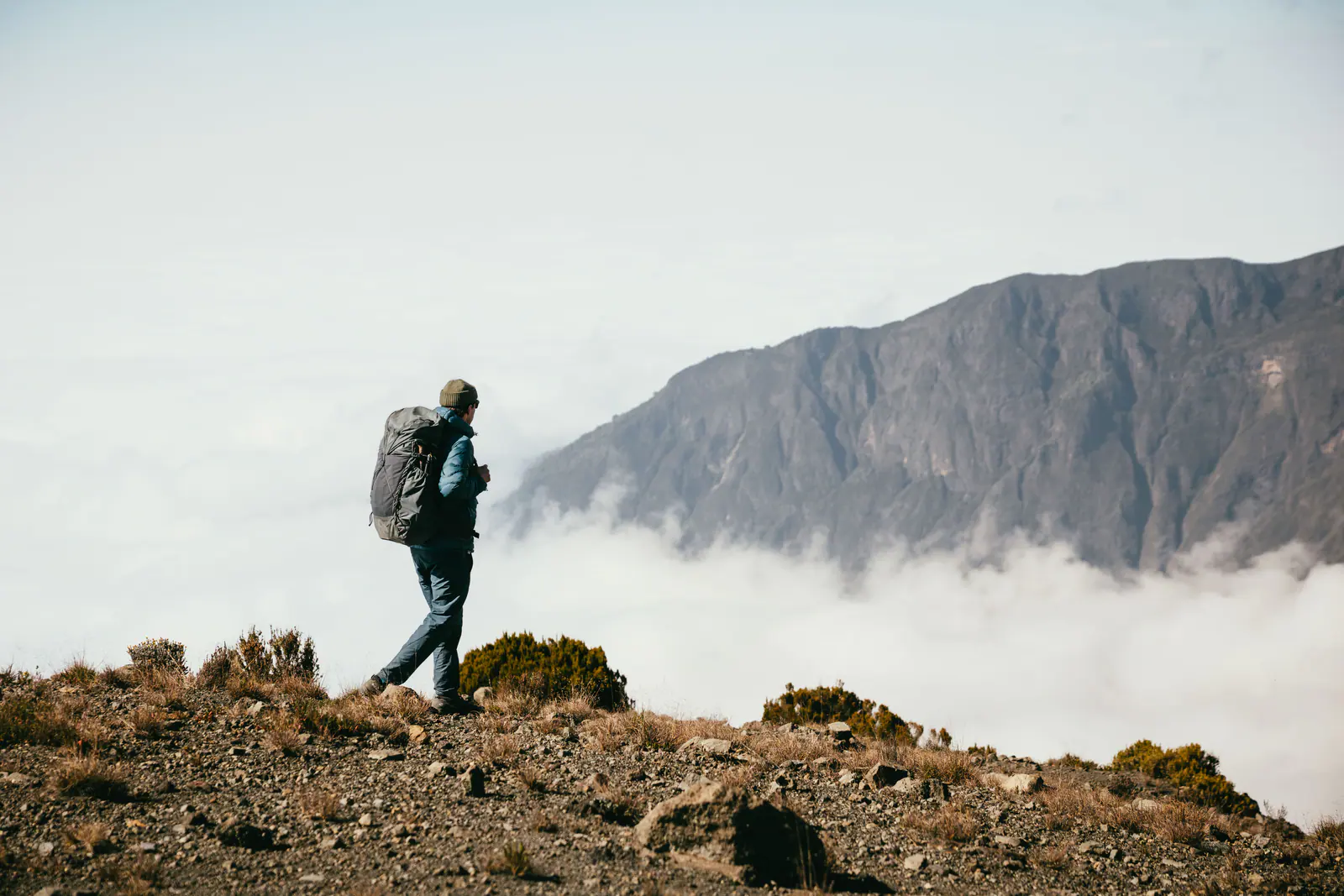 A trekker high on the mountain above a sea of clouds
