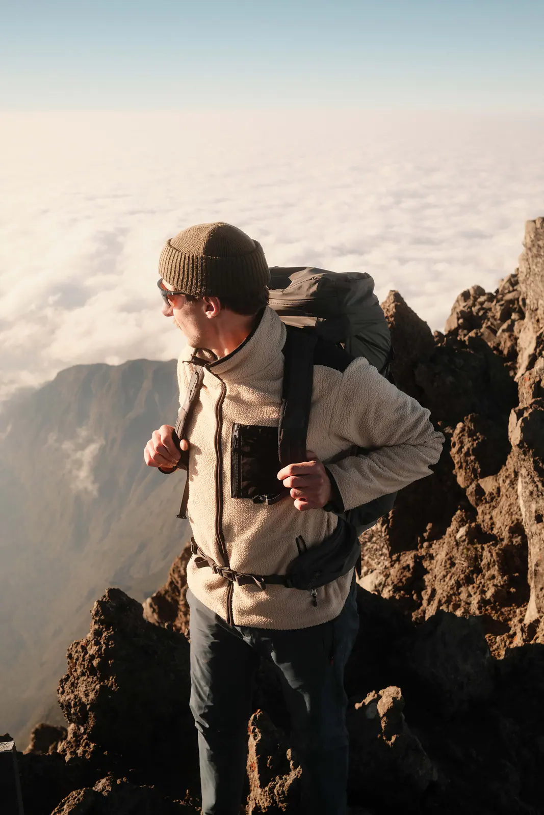 Un excursionista en lo alto de la montaña sobre un mar de nubes
