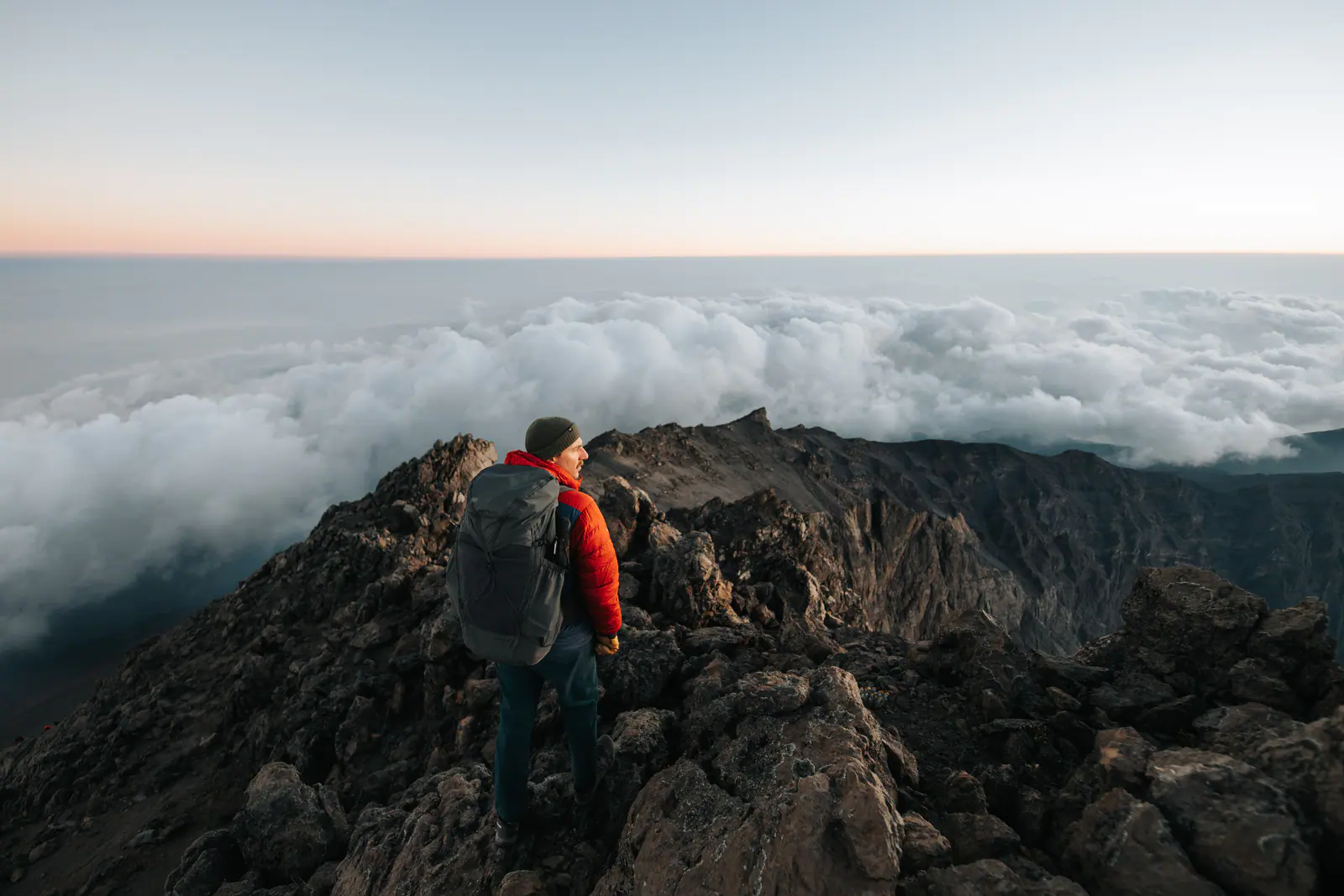 A trekker high on the mountain above a sea of clouds