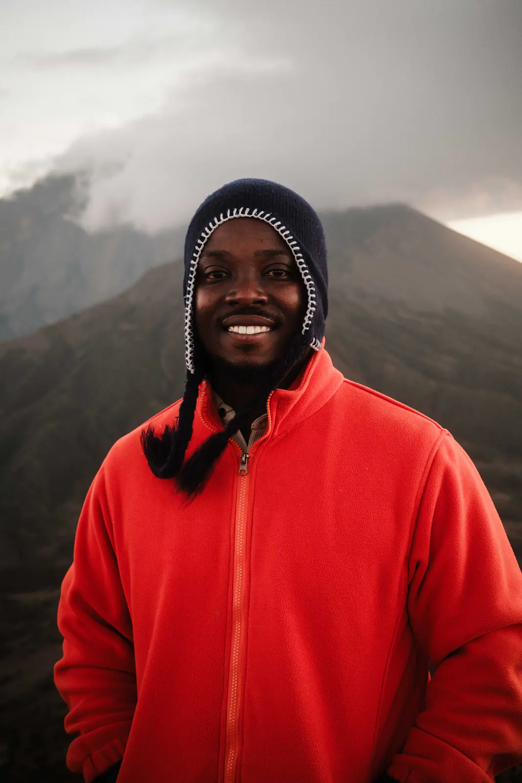 Un guía de montaña con forro rojo sonriendo a cámara