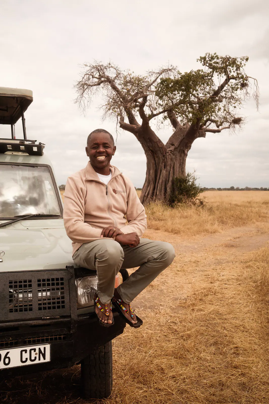 Ein Safariguide neben seinem Fahrzeug in Tarangire
