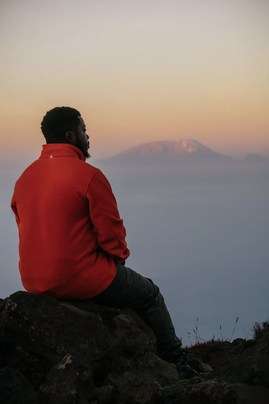 A guide looking toward Kilimanjaro at sunset