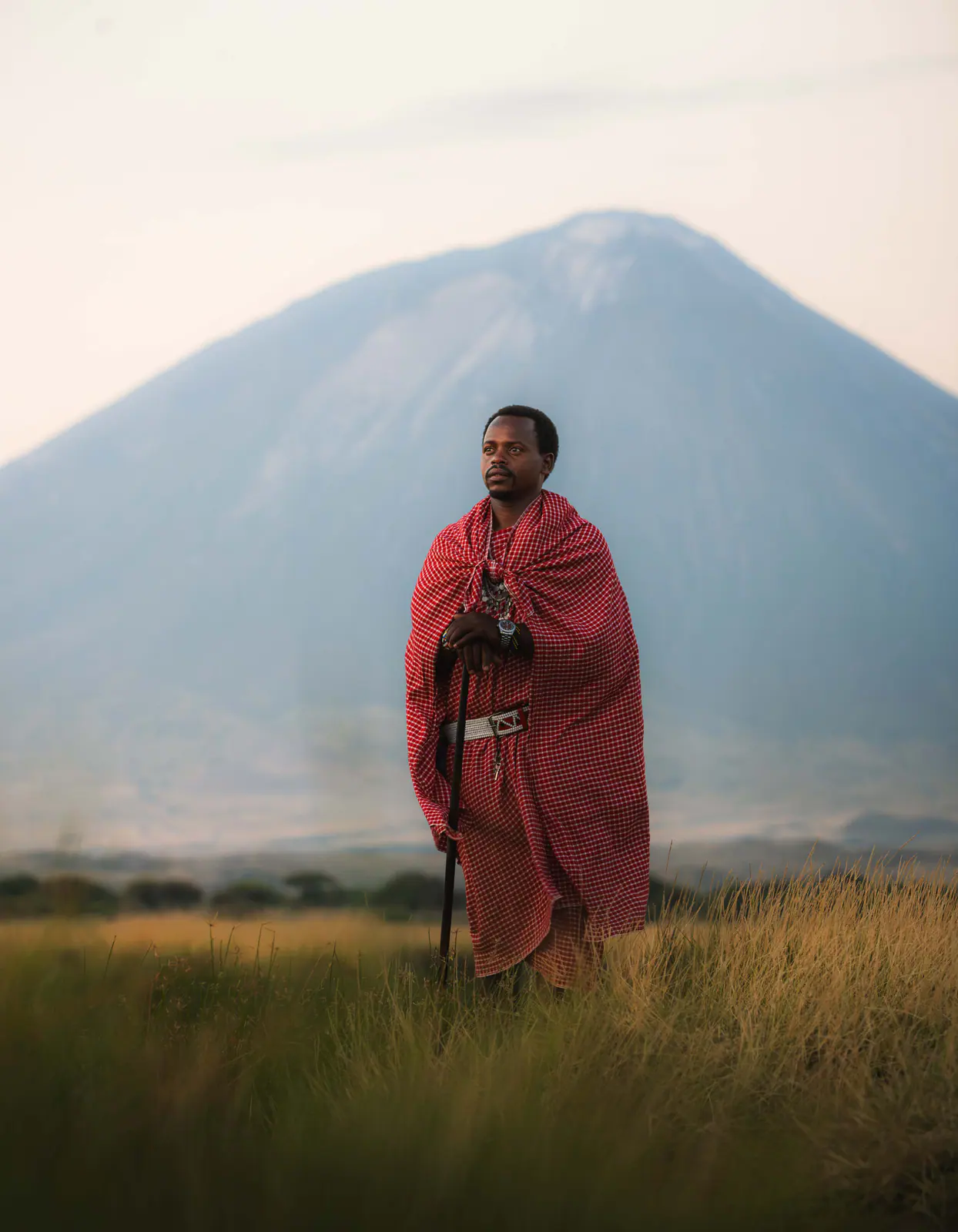 A Maasai man in a red shuka beneath Ol Doinyo Lengai