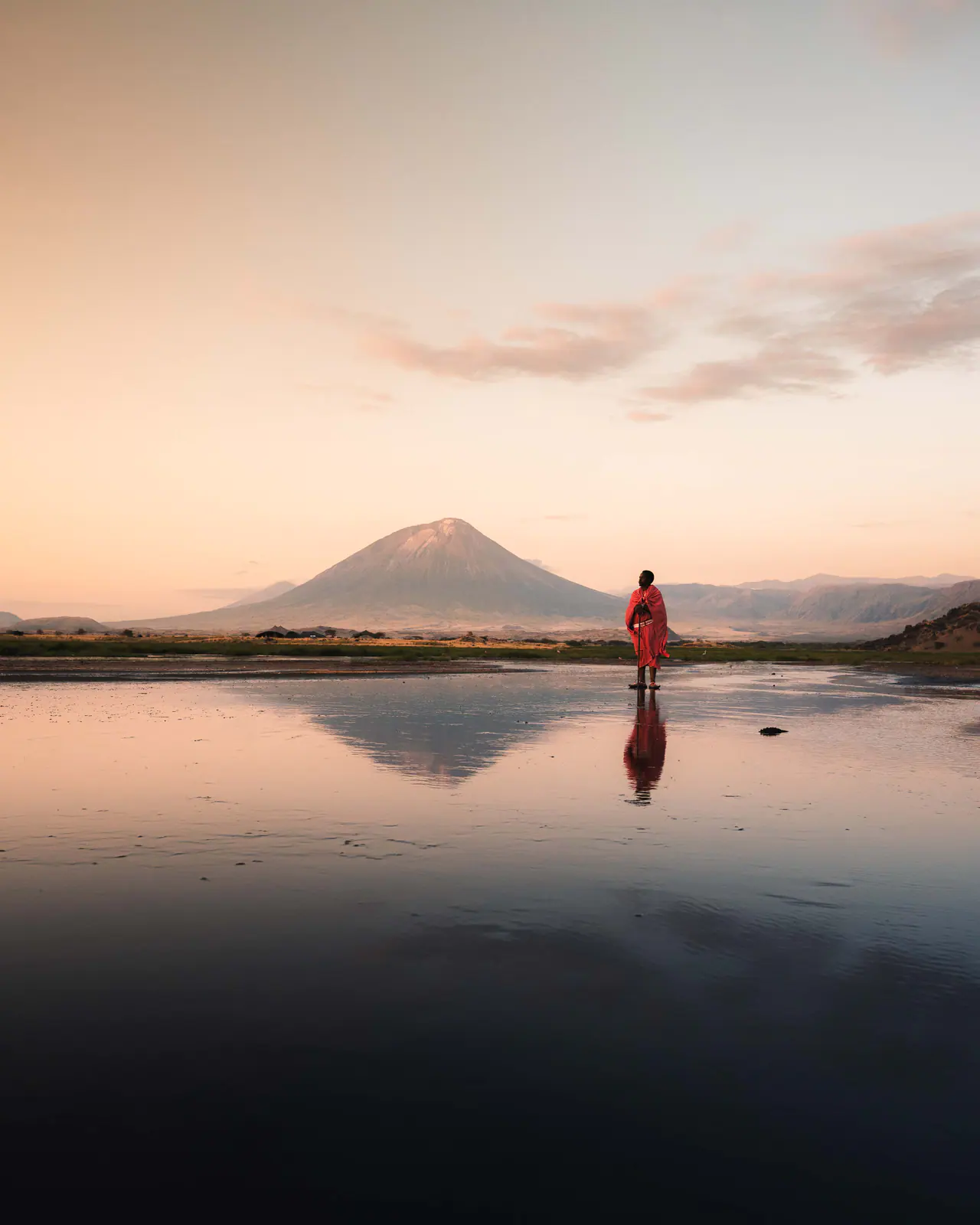 A Maasai man in a red shuka beneath Ol Doinyo Lengai