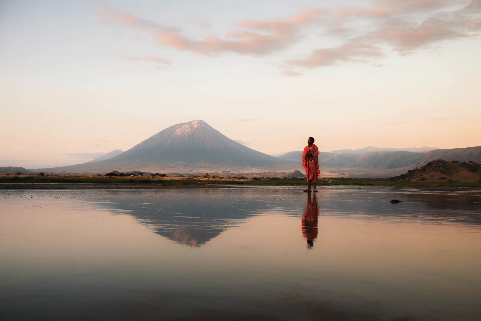 A Maasai man in a red shuka beneath Ol Doinyo Lengai