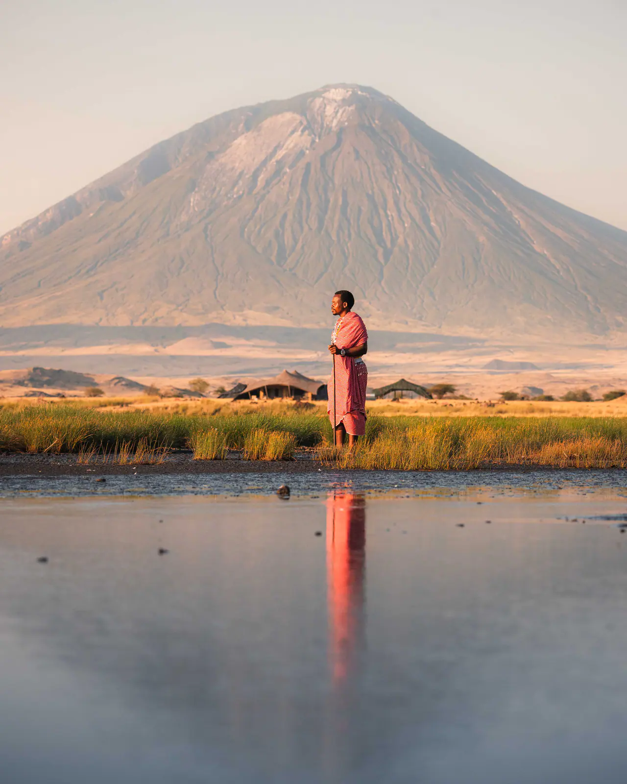 A Maasai man in a red shuka beneath Ol Doinyo Lengai
