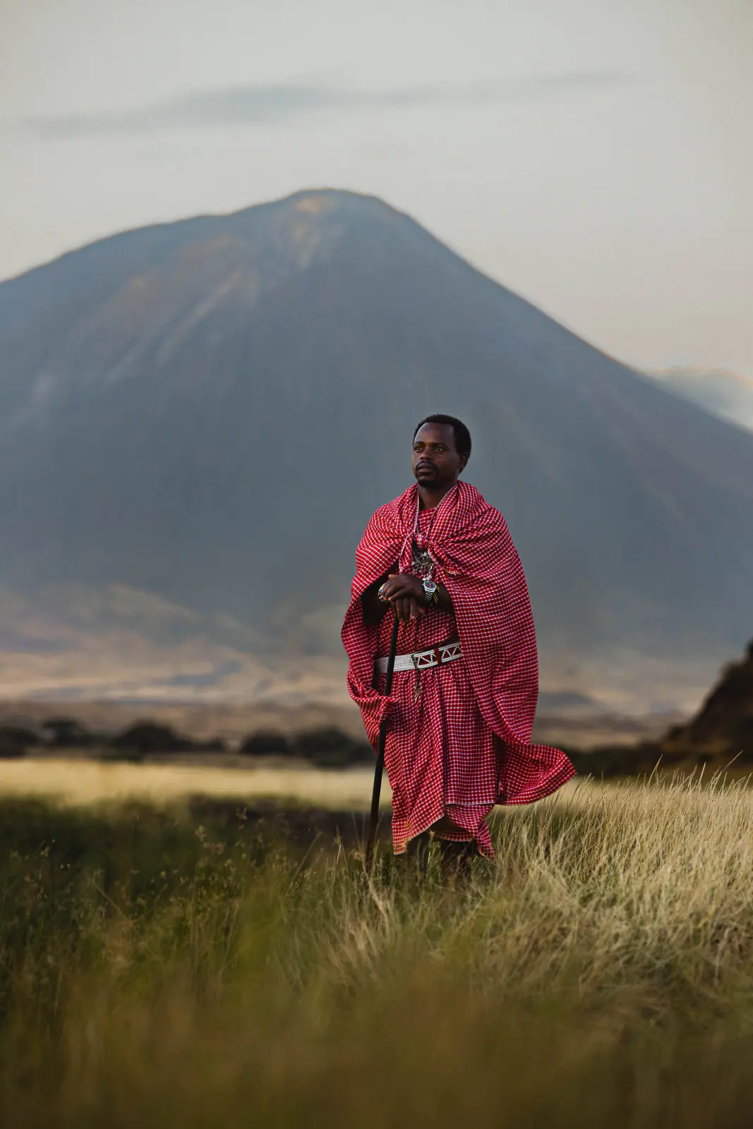 A Maasai man in a red shuka beneath Ol Doinyo Lengai