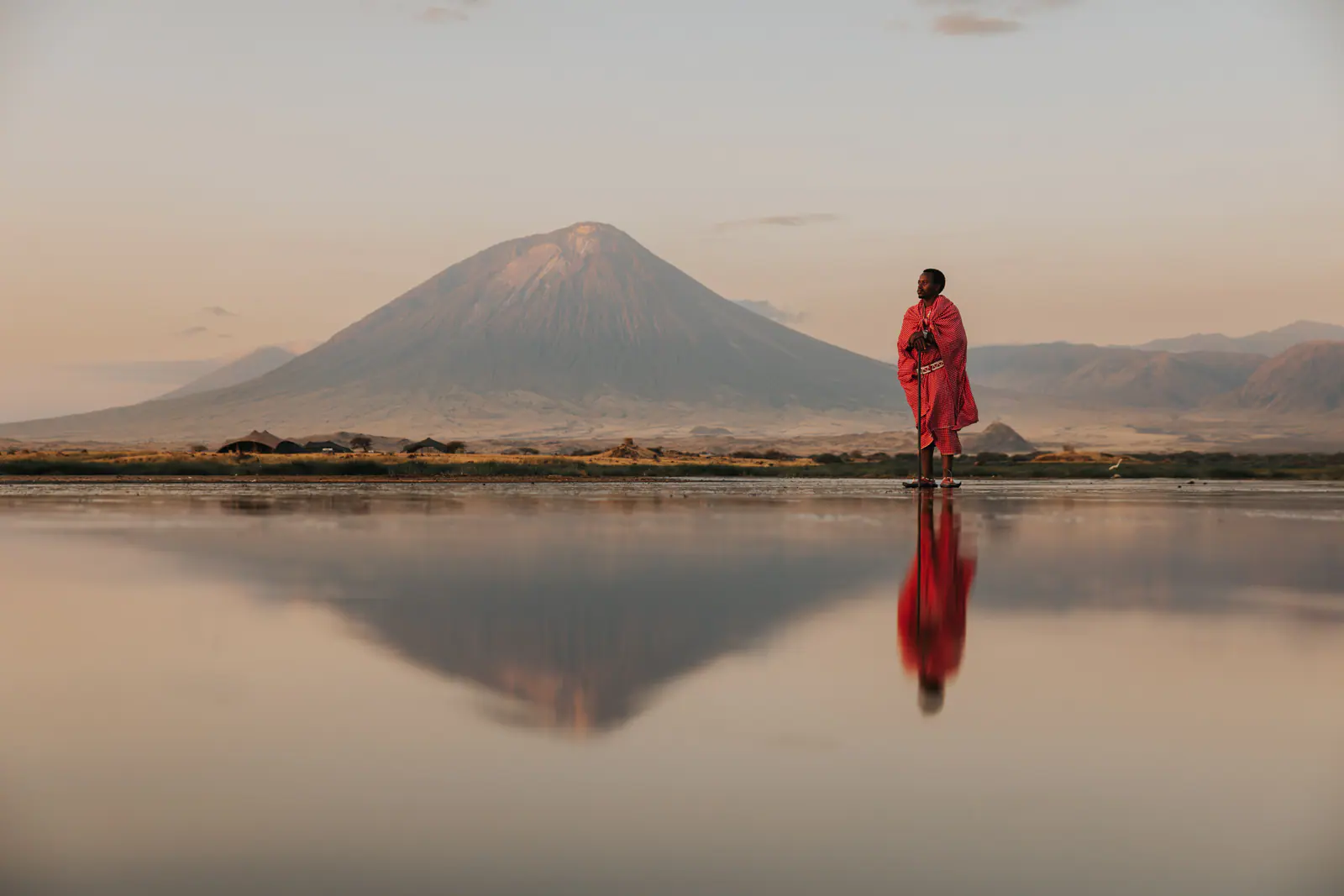 A Maasai man in a red shuka beneath Ol Doinyo Lengai