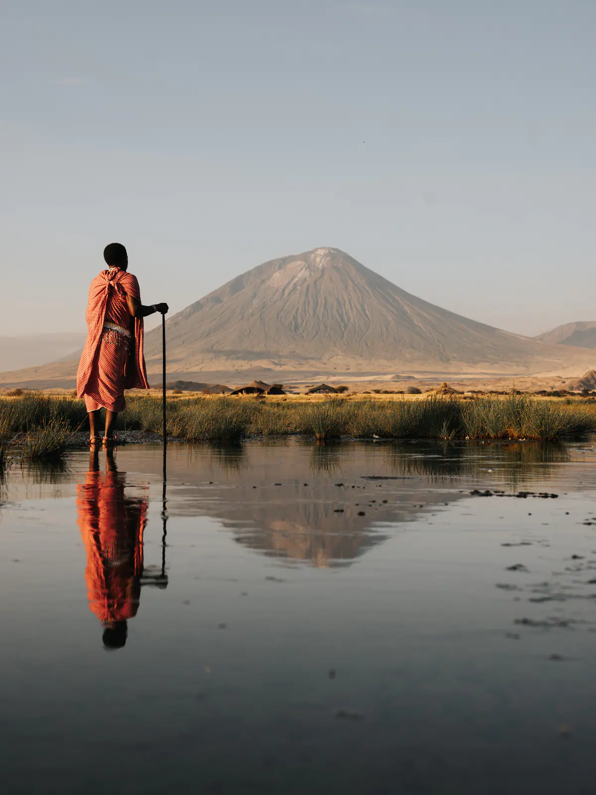 A Maasai man in a red shuka beneath Ol Doinyo Lengai