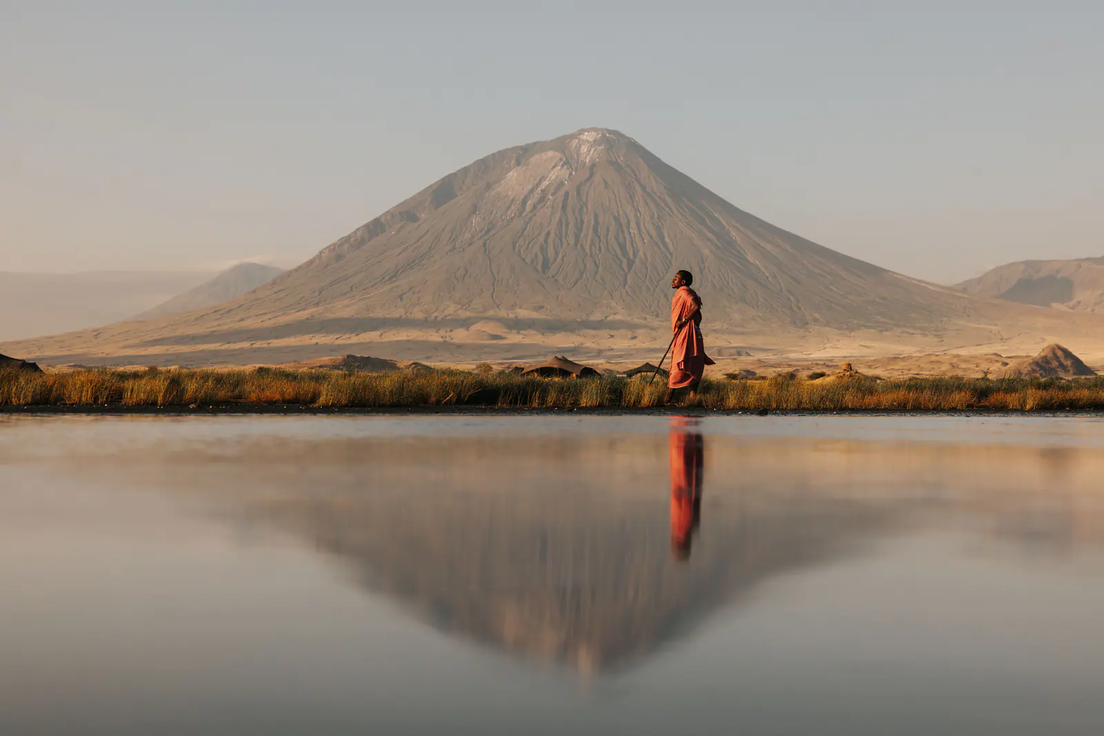 A Maasai man in a red shuka beneath Ol Doinyo Lengai