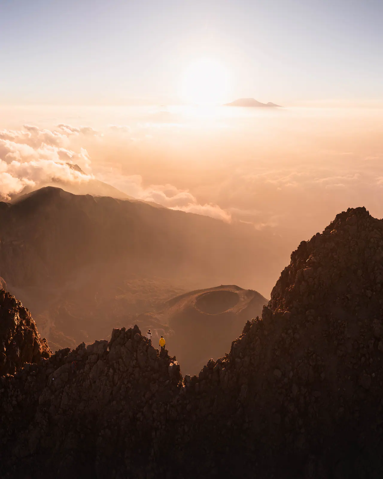 A lone trekker on a jagged ridge at sunrise