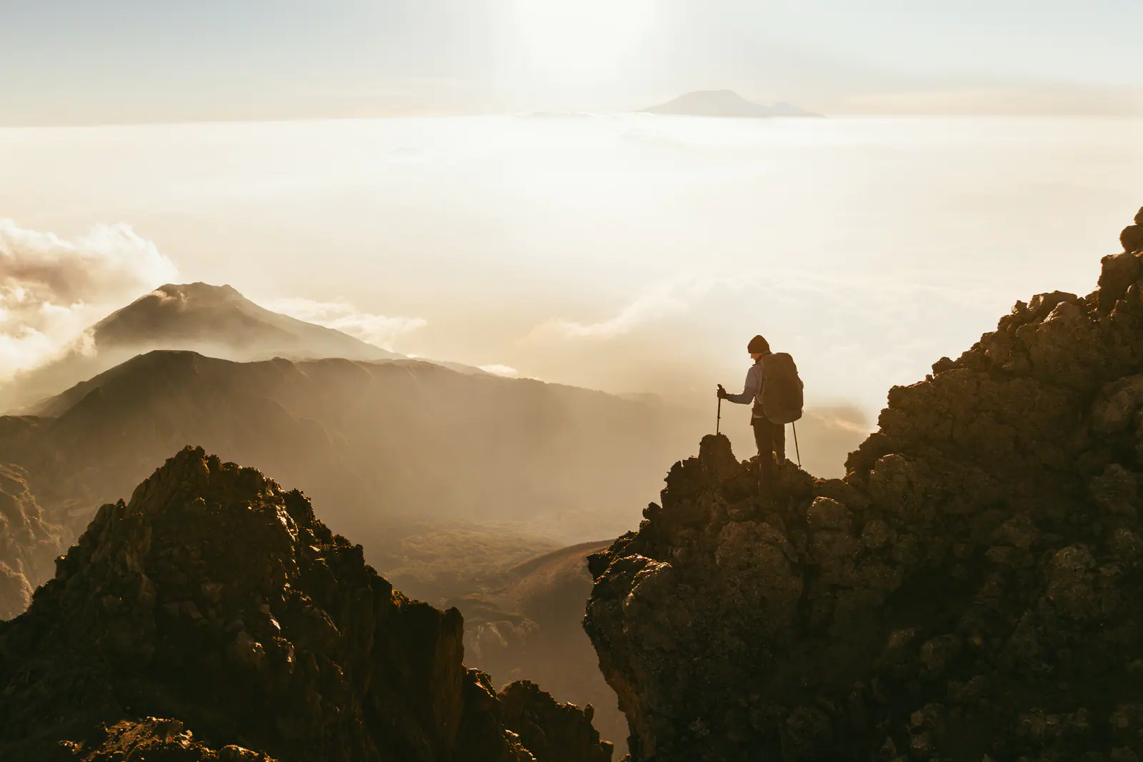 Ein einzelner Wanderer auf einem zerklüfteten Grat bei Sonnenaufgang