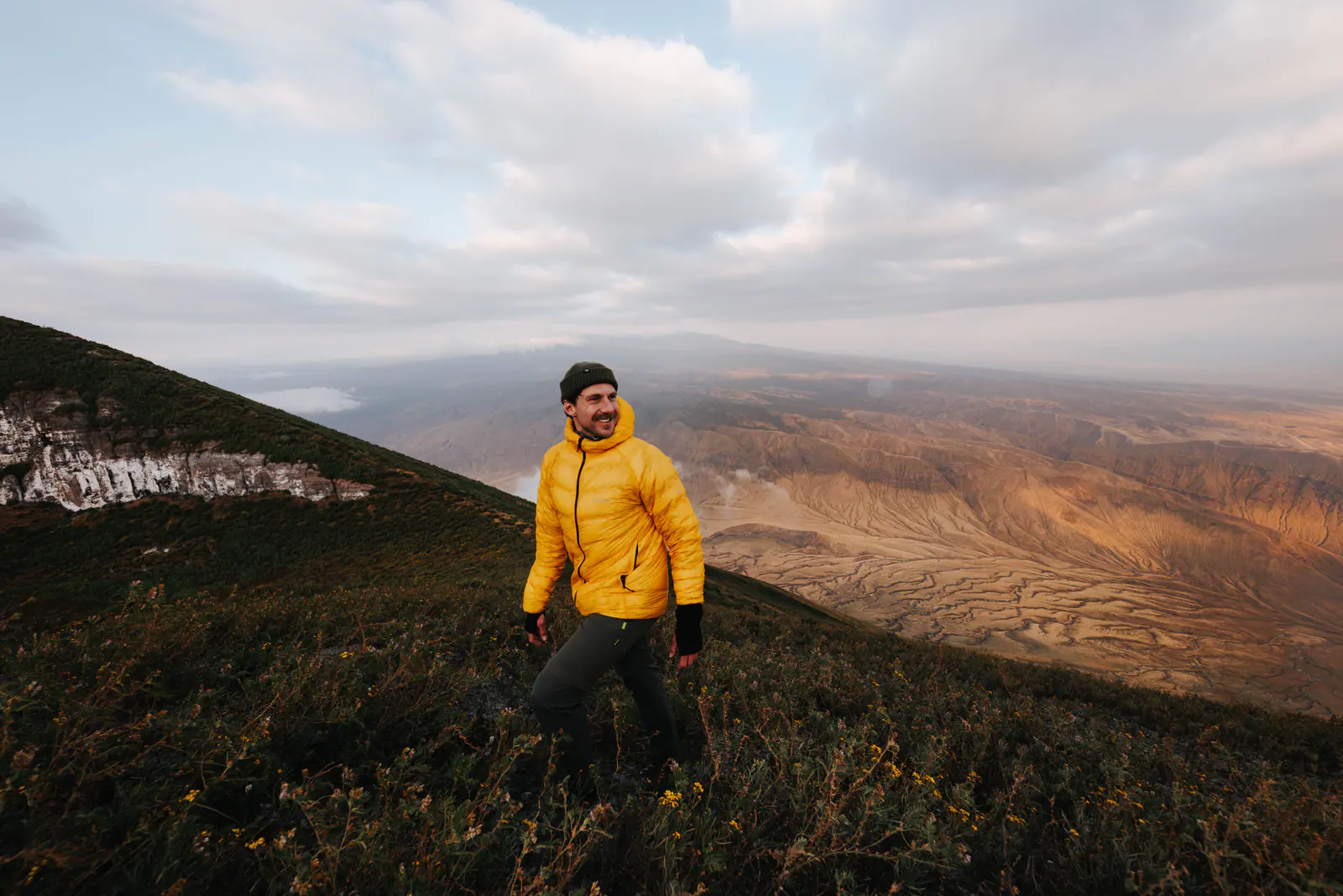 A trekker resting on a mountain ridge at sunrise
