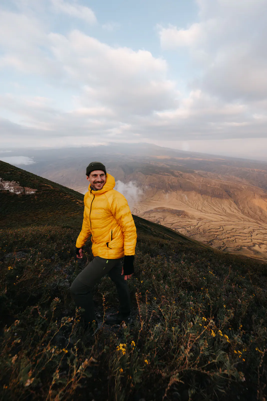 A trekker resting on a mountain ridge at sunrise