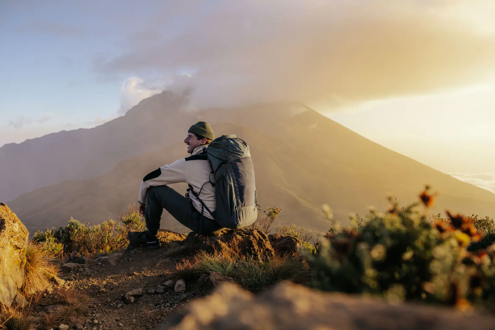 Un excursionista descansando en una cresta al amanecer