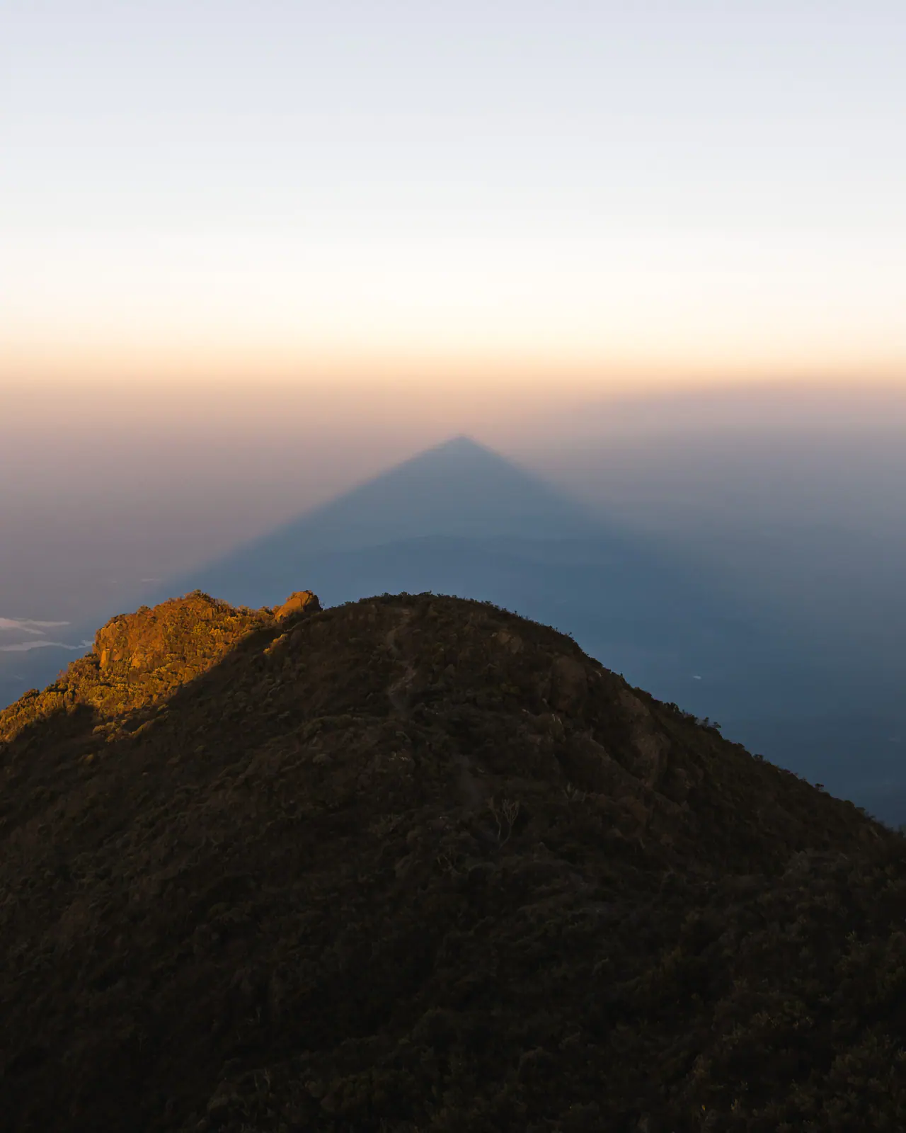 Luz dorada sobre una cumbre volcánica por encima de las nubes