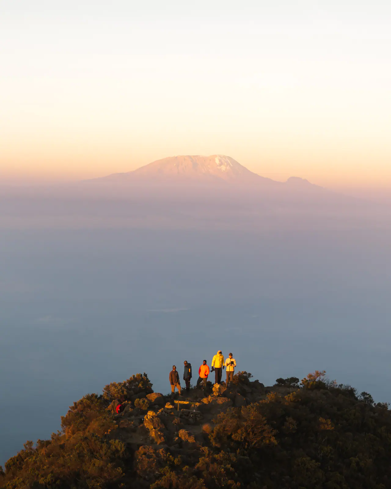 Golden light over a volcanic summit above the clouds