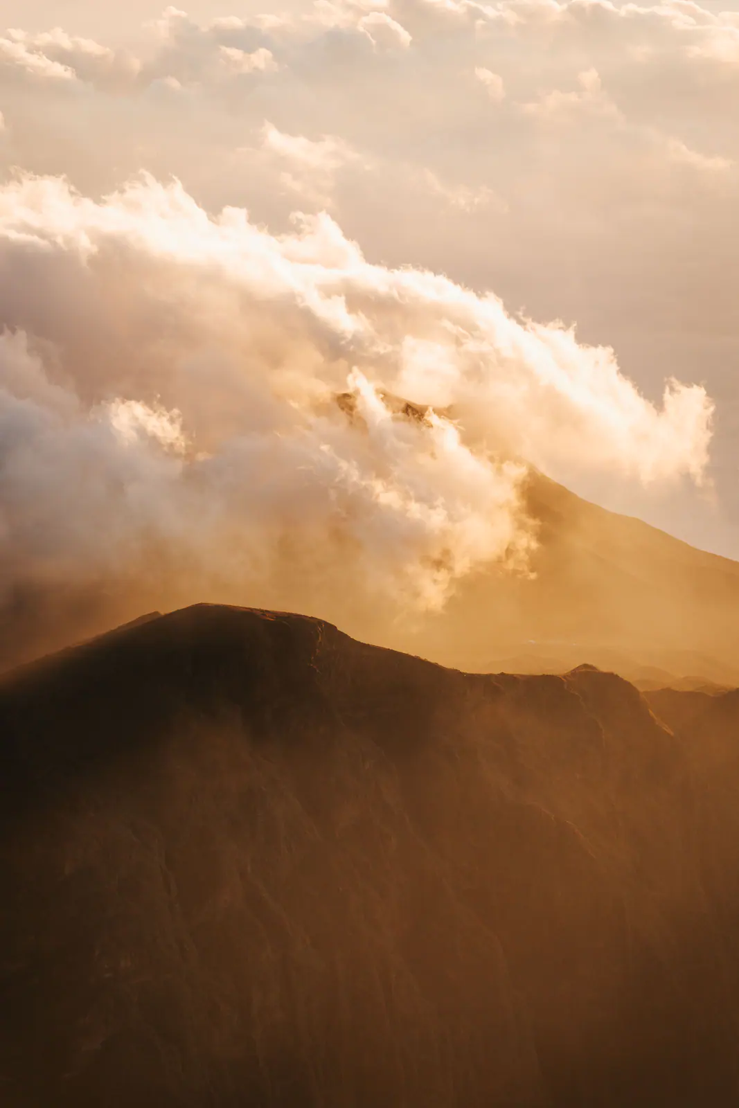 Luz dorada sobre una cumbre volcánica por encima de las nubes