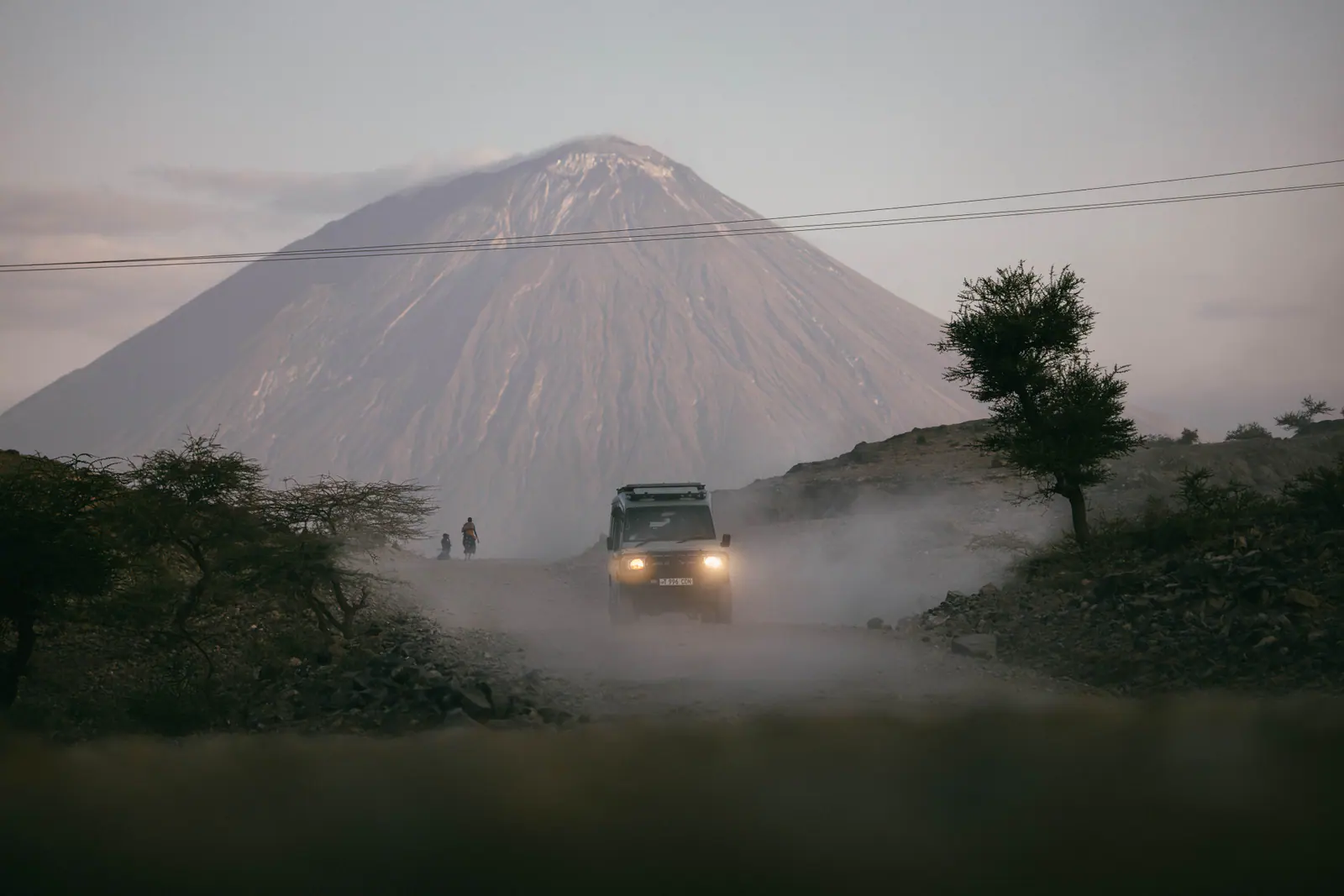 A safari vehicle beneath Ol Doinyo Lengai
