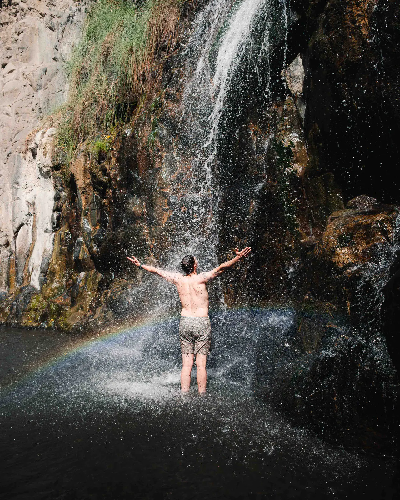 A traveller standing beneath a waterfall