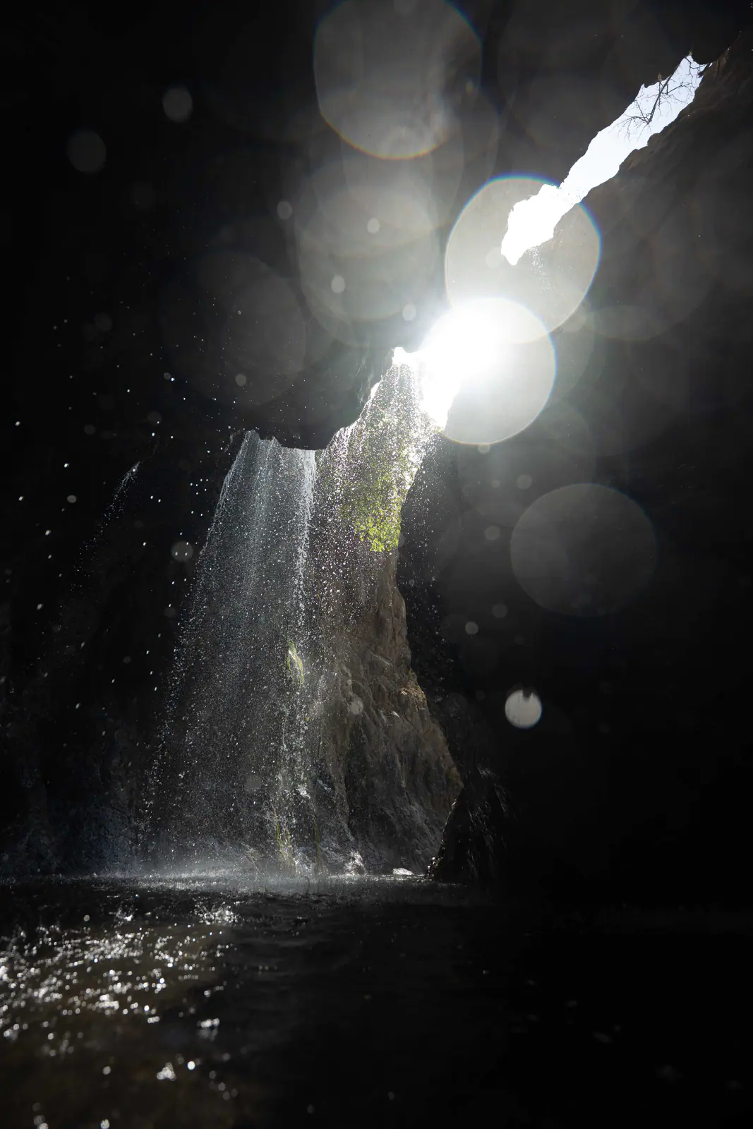 A traveller standing beneath a waterfall