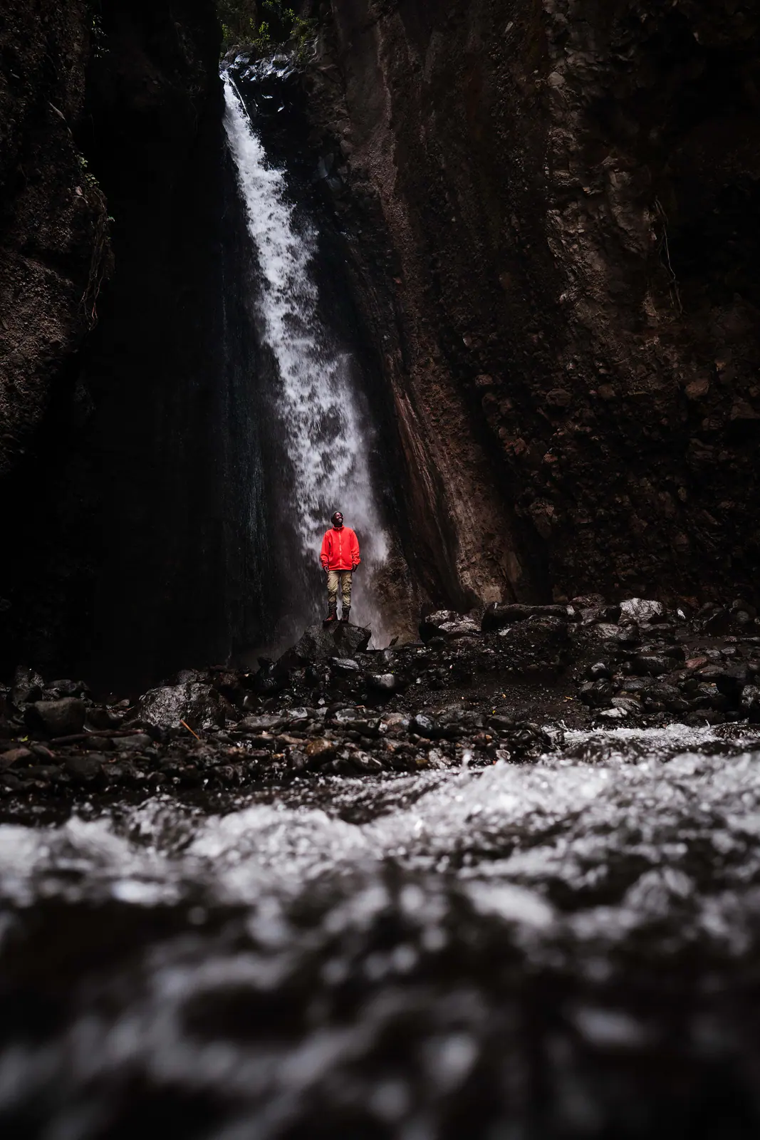 A traveller standing beneath a waterfall